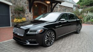 Elegant black limo parked and ready for wedding guests in a scenic outdoor setting in Connecticut